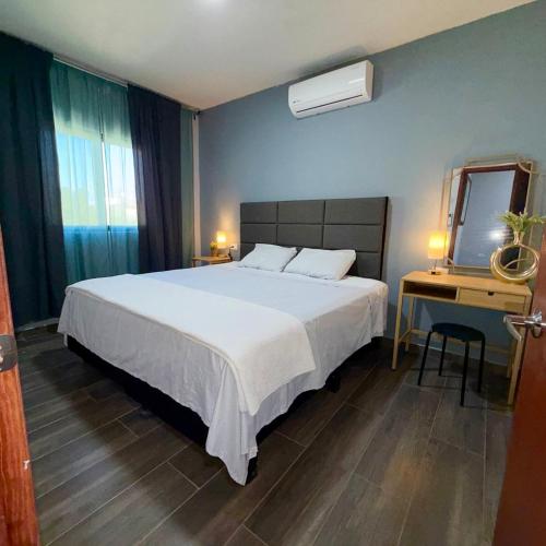 a bedroom with a bed and a desk and a mirror at Casa Conchalito in La Paz