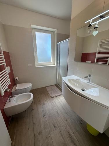 a bathroom with a sink and a toilet and a mirror at appartamentsandreis in Malcesine