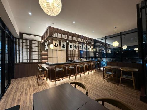 a restaurant with tables and chairs and a bar at PIA Hotel Bandung in Bandung