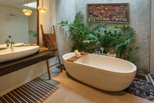 a bathroom with a large tub and a sink at Private beach Oceanfront 3bd Villa in Cemagi