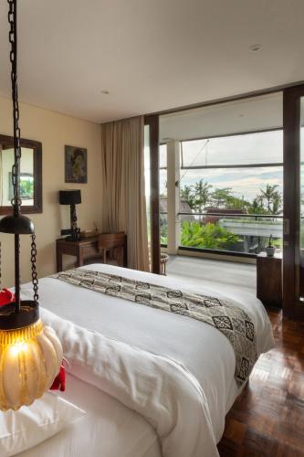 a bedroom with a large bed with a large window at Private beach Oceanfront 3bd Villa in Cemagi