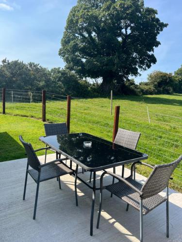 ein Tisch und Stühle auf einer Terrasse mit einem Feld in der Unterkunft Hideaway21 in Maghera