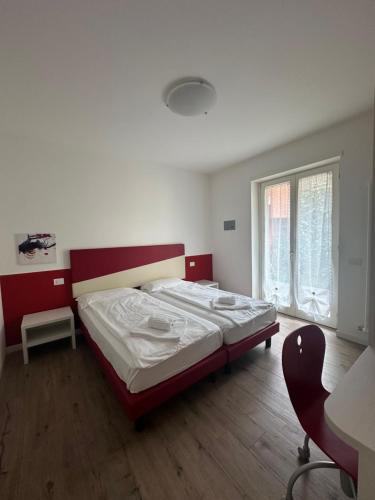 a bedroom with a bed and a desk and a chair at appartamentsandreis in Malcesine
