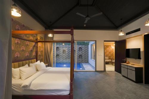 a bedroom with a bed and a television in it at Vanasya Retreat Corbett in Amgarhi