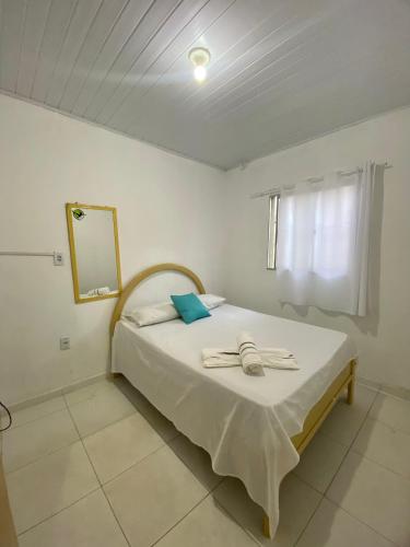 a bedroom with a bed with a mirror and a window at Pé na Villa in Itacaré