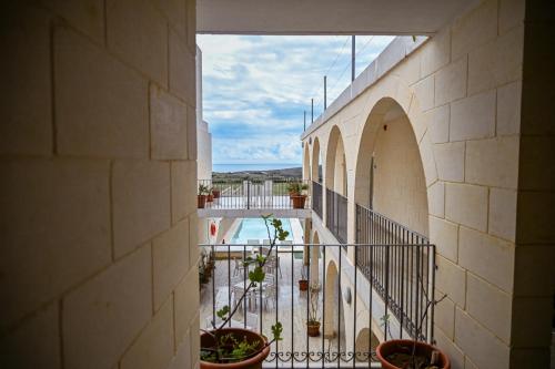 a view from the balcony of a building with potted plants at Ta' Battista B&B with Pool - Gozo in Xewkija