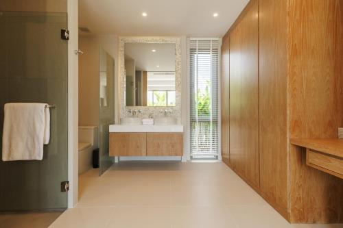 a bathroom with a sink and a large mirror at Trichada Essence in Ban Pak Lak