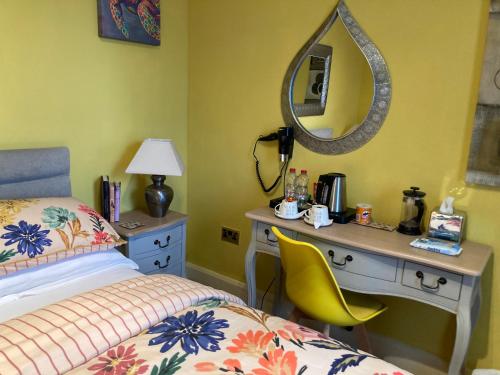 a bedroom with a desk and a bed and a mirror at Mountroyal Victorian Self Catering Apartment 2 in Belfast
