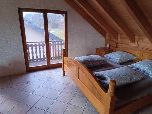 two beds in a room with a large window at Ferienwohnung Bermbach in Weilburg