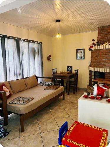 a living room with a couch and a table at Casa completa com lareira, piscina compartilhada in Torres