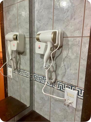 a hair dryer and a phone on a wall at Casa completa com lareira, piscina compartilhada in Torres
