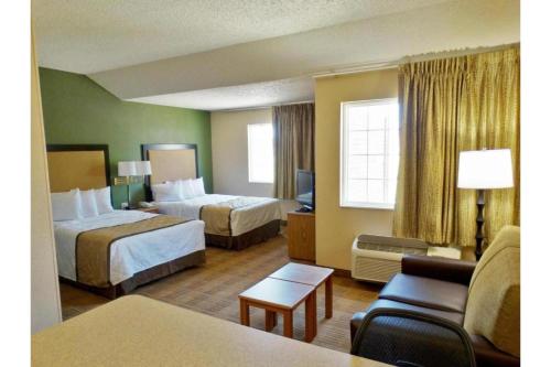 a hotel room with two beds and a couch at Studio 6 Extended Stay Fishkill Route 9 NY in Fishkill