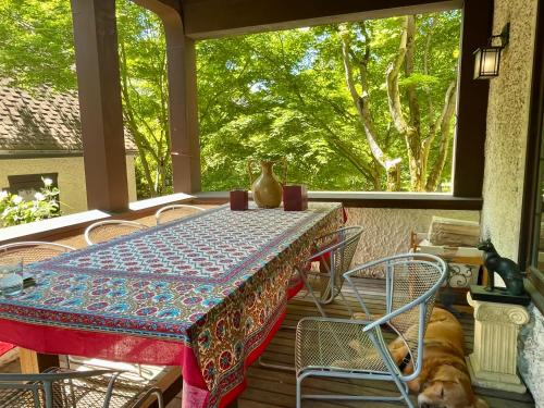 a table and chairs on a porch with a dog at Cecil Bacon Manor in Seattle