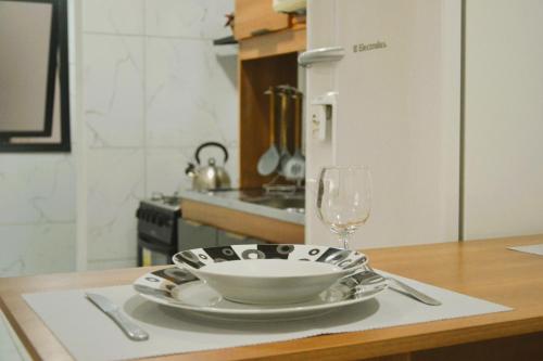 a table with a bowl and a glass of wine at Refúgio completo com Ar condicionado e enxoval in Pelotas