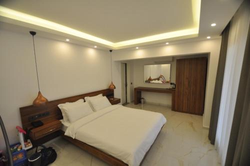 a bedroom with a white bed and a mirror at Villa Port Bodrum in Bodrum City