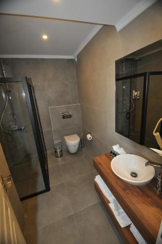 a bathroom with a sink and a shower and a toilet at Villa Port Bodrum in Bodrum City