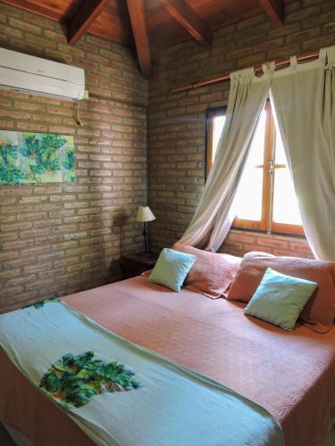 a bedroom with two beds and a window at Cabañas La Aldea in Villa Carlos Paz