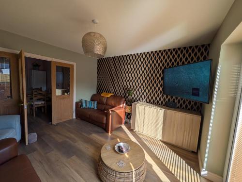 a living room with a couch and a flat screen tv at Beachwood in Skegness
