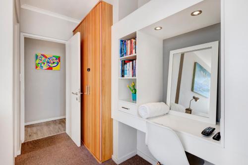 a bathroom with a mirror and a white sink at Cape Town, Blouberg Beachfront Luxury Apt - Kite Beach in Bloubergstrand