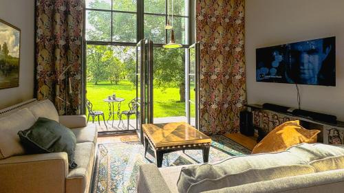 a living room with a couch and a large window at Lossipark Guest Apartments - vis-à-vis Bishop's Castle in Haapsalu