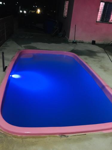 a blue swimming pool in a garage at night at Casa da BARBIE Praia in Itapipoca