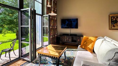 a living room with a couch and a large window at Lossipark Guest Apartments - vis-à-vis Bishop's Castle in Haapsalu