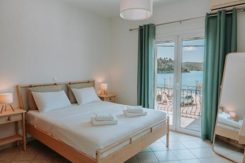 a bedroom with a bed with a view of the ocean at Teal Seafront Home in Syvota