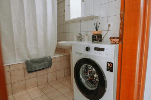 a washing machine in a bathroom with a sink at Teal Seafront Home in Syvota