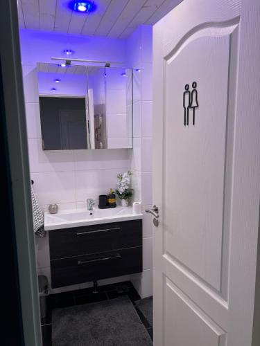 a white bathroom with a sink and a mirror at Andrelle Rental in Tõrvandi