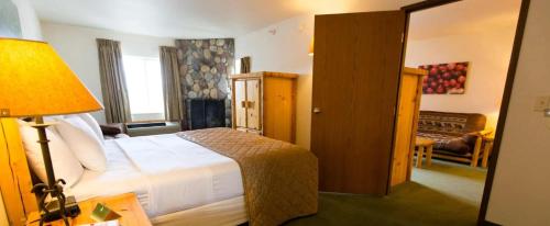 a bedroom with a bed with a lamp and a living room at Cranberry Country Lodge in Tomah