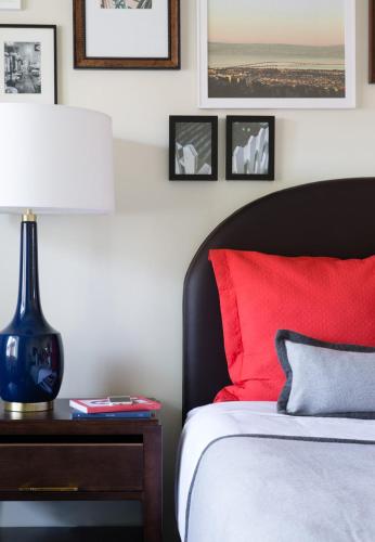 a bedroom with a red bed and a table with a lamp at LiA Hotel in San Carlos