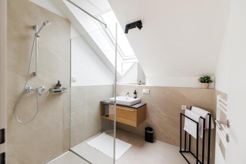 a bathroom with a shower and a sink at Das Salzamt - Boutique Apartments in Gmunden