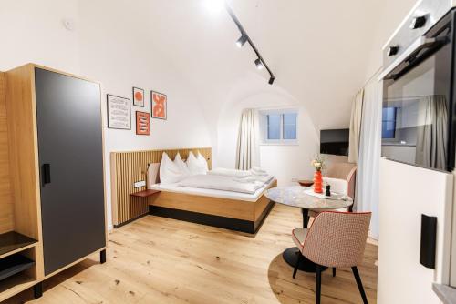 a hotel room with a bed and a table at Das Salzamt - Boutique Apartments in Gmunden