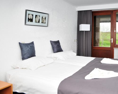a hotel room with two beds and a window at Hotel Eperland in Epen