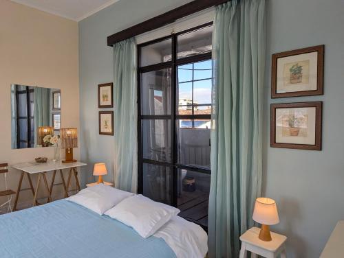 a bedroom with a bed and a large window at quarto duplo downtown in Ponta Delgada