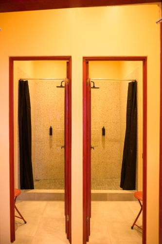 two glass doors in a bathroom with a shower at Casa Remolacha in Flores