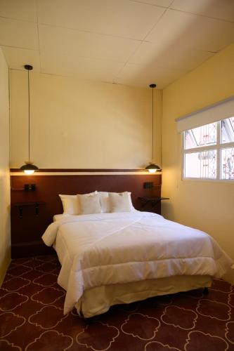 a bedroom with a large bed and a window at Casa Remolacha in Flores