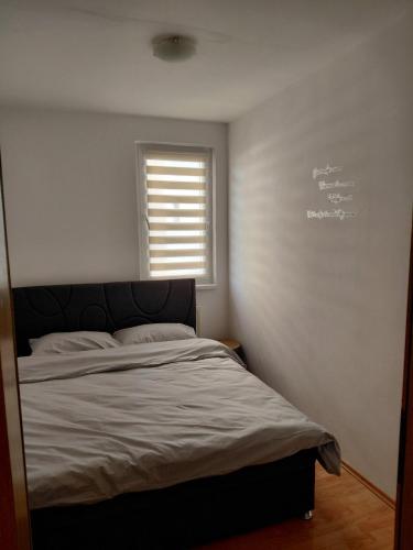 a bedroom with a bed and a window with a chalkboard at LOBO stan na dan in Lukavica