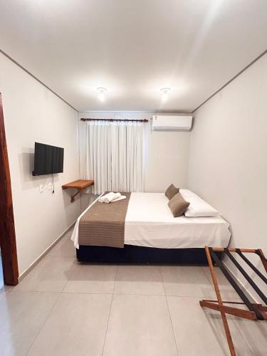 a bedroom with a bed and a television in it at Môzzi Barra Grande in Barra Grande