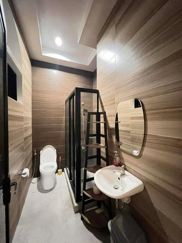 a bathroom with a sink and a mirror and a toilet at T'zam Villa in Dipolog