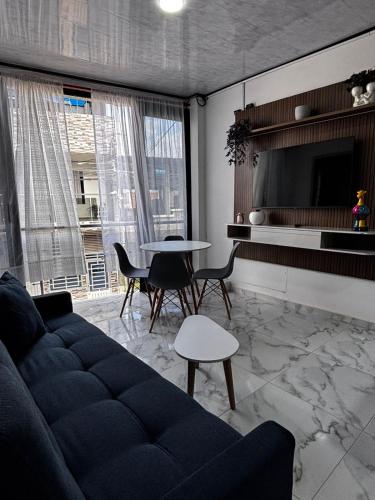 a living room with a couch and a table at Aparta Hotel La Osadía in Acacías