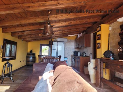 a living room with a couch and a kitchen at Rifugio della Pace Piano terra e Primo Piano in Sant' Isidoro