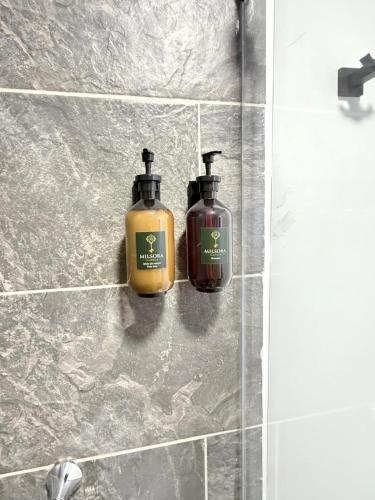 two bottles of soap on a wall in a bathroom at Loft 4 Bambú in Laureles Stadium in Medellín