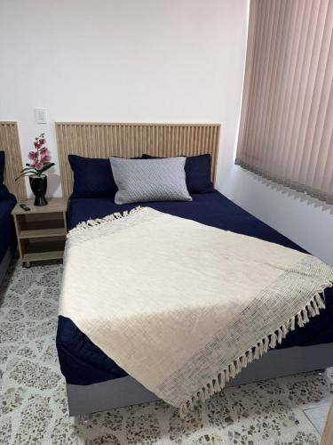 a bedroom with a bed with blue and white sheets at Loft 4 Bambú in Laureles Stadium in Medellín