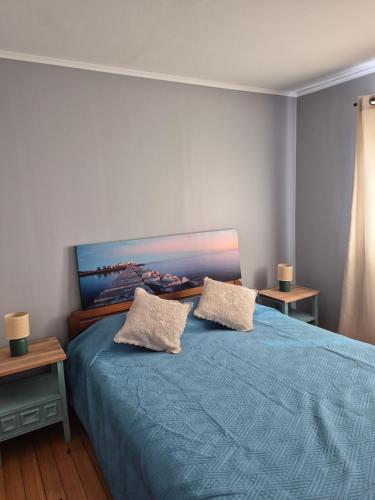 a bedroom with a blue bed with two pillows at Casa Montes Valle Alegre in Quintero