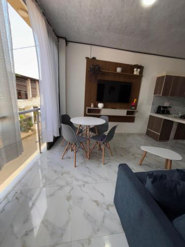 a living room with a table and chairs and a tv at Aparta Hotel La Osadía in Acacías
