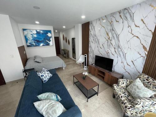 a living room with a blue couch and a television at Risco Centro de Bucerías beachfront with pool in Bucerías