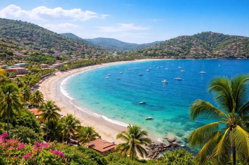 a beach with palm trees and boats in the water at Fabuloso Hotel Las Vegas in Zihuatanejo