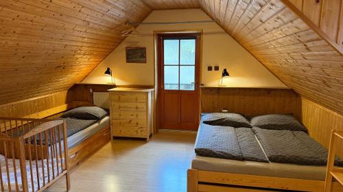 two beds in a room with a attic at Domeček Karlov in Malá Morávka