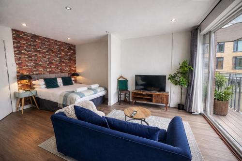 a living room with a bed and a couch and a bedroom at FruitTrees Serviced Apartment in Cambridge